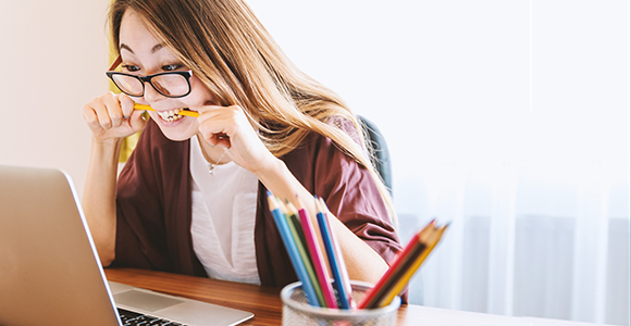 Frustrated woman biting pencil